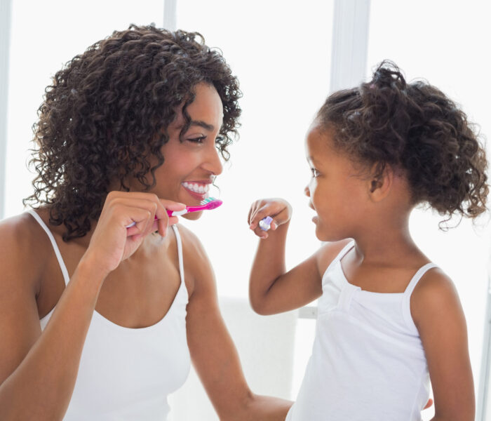 Pretty,Mother,With,Her,Daughter,Brushing,Their,Teeth,At,Home